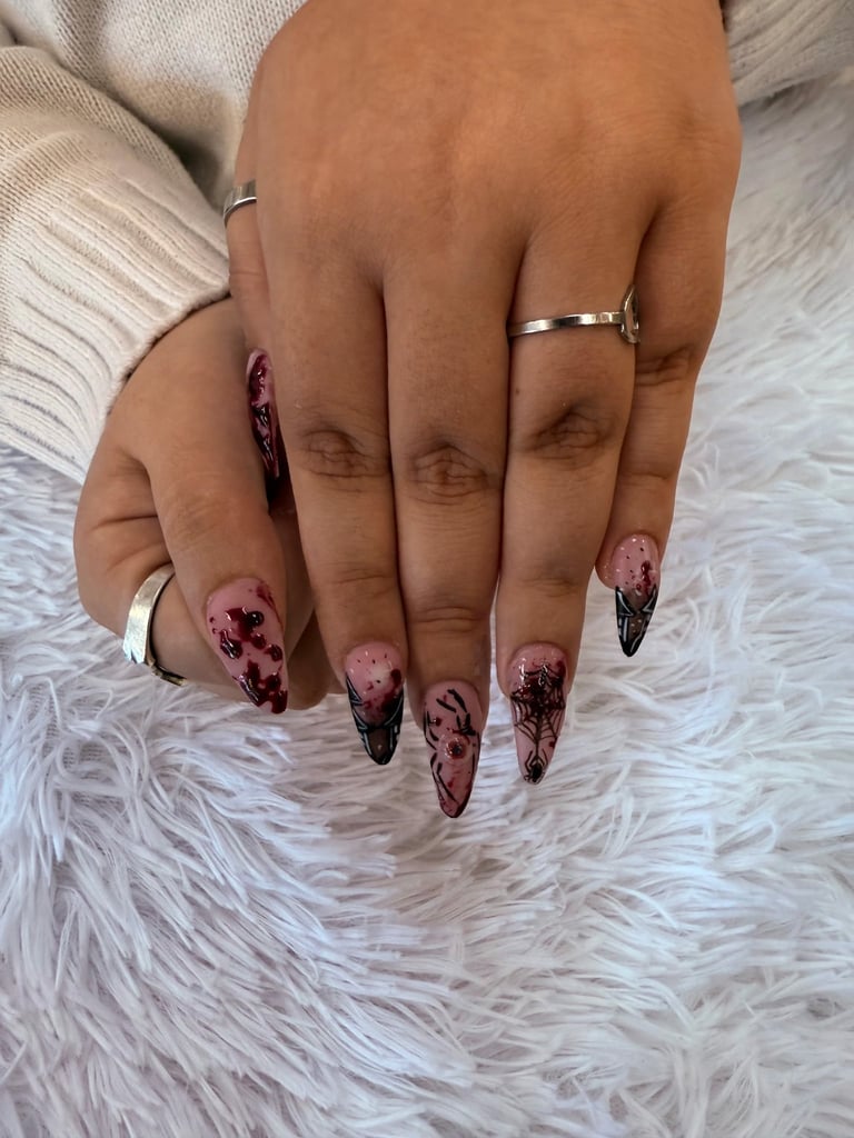 Close-up of manicured hands with pink and black ombre stiletto nails, silver ring, on white fluffy fabric