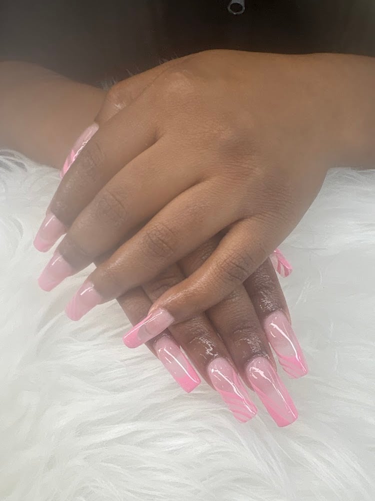 Close-up of hands with long pink and white ombre acrylic nails resting on white fluffy fabric