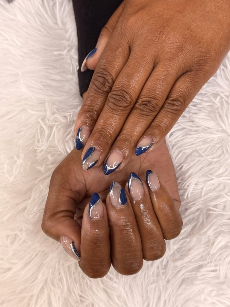 Close-up of hands showing manicured nails with blue and white curved nail art design on white textured background
